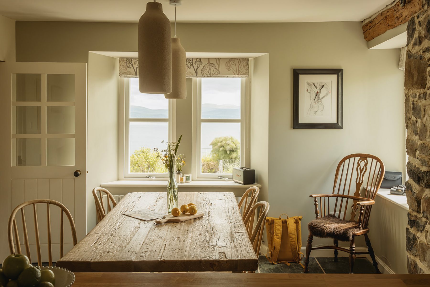 Inside the Croft House kitchen at Geary, Skye. A traditional cottage kitchen with wooden table, chairs and a view to the sea.