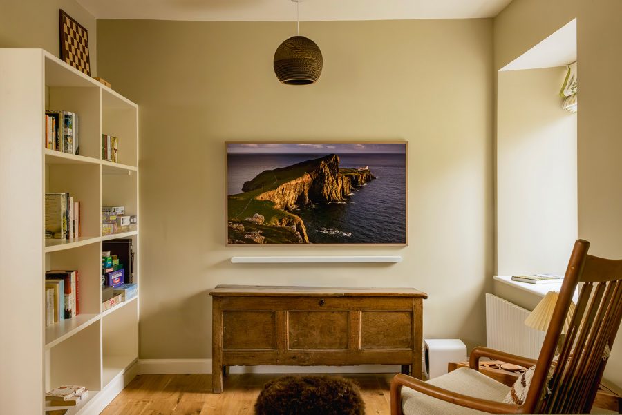 Library area in sitting room in the Croft House at Mint Croft, Skye. Large built in book shelves, wooden chest, wooden easy chair