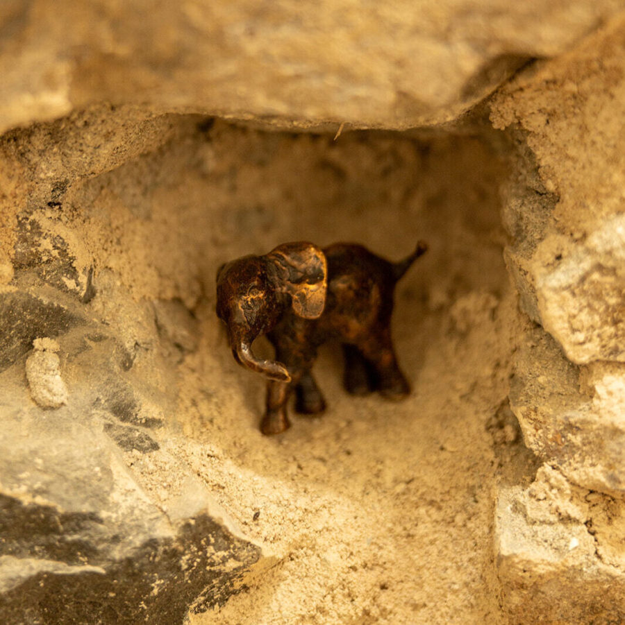 Bronze elephant sculpture nestling in a stone wall at Mint Croft.